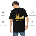 Person wearing a black t-shirt with gold 'Köln' and cathedral design on the back, with quality attributes listed.