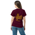 Person wearing a maroon t-shirt with 'KOLN' and a cathedral design on the back.