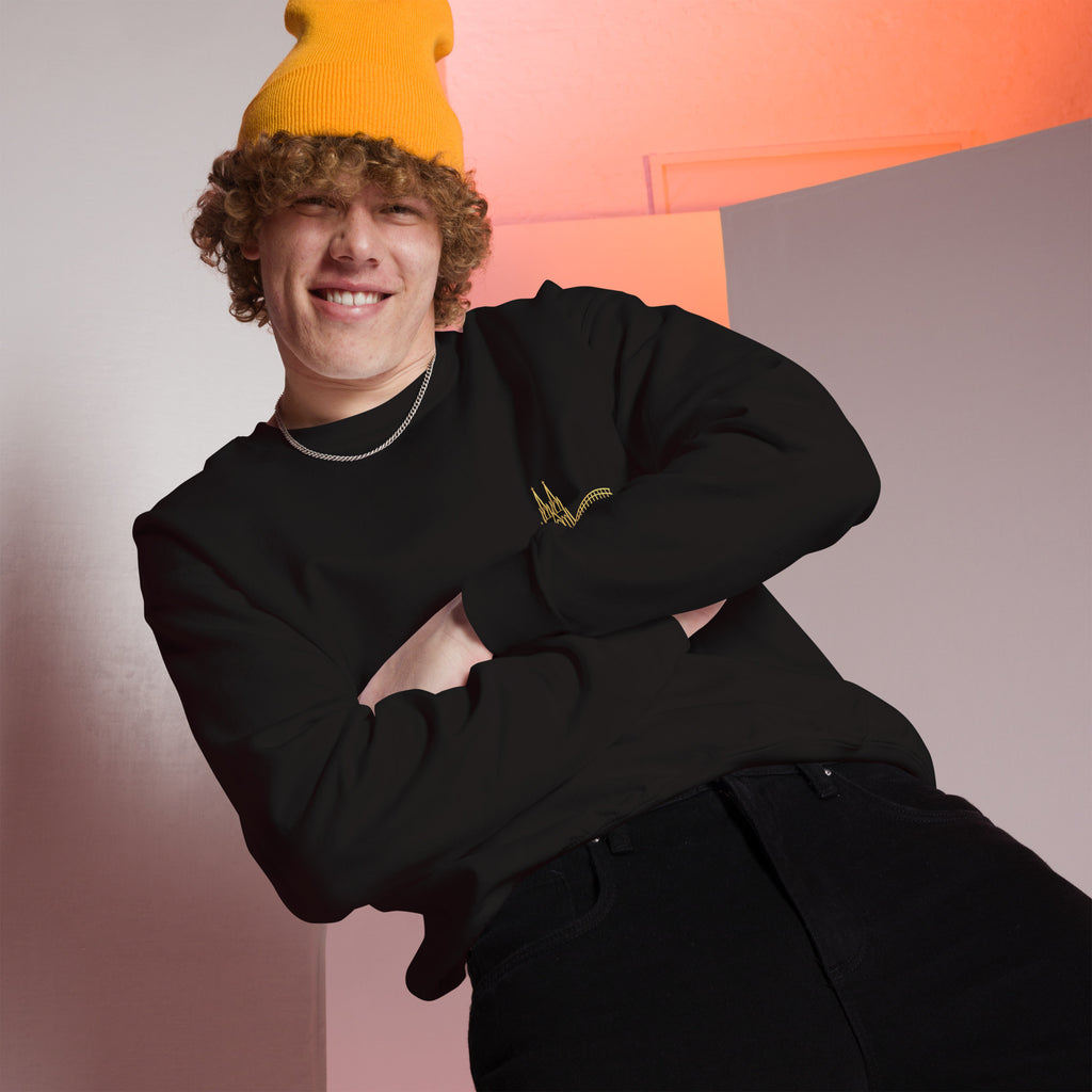 Person wearing a black outfit with a yellow beanie against a colorful geometric background