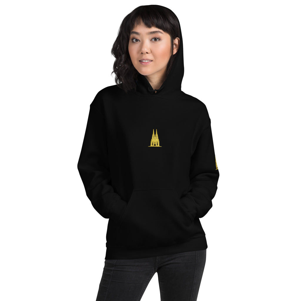 Person wearing a black hoodie with a Köln golden logo on a white background