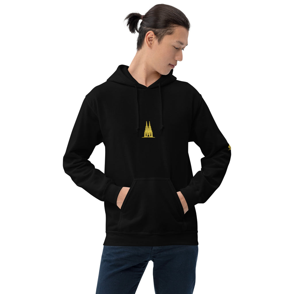 Person wearing a black hoodie with a Köln gold logo on a white background