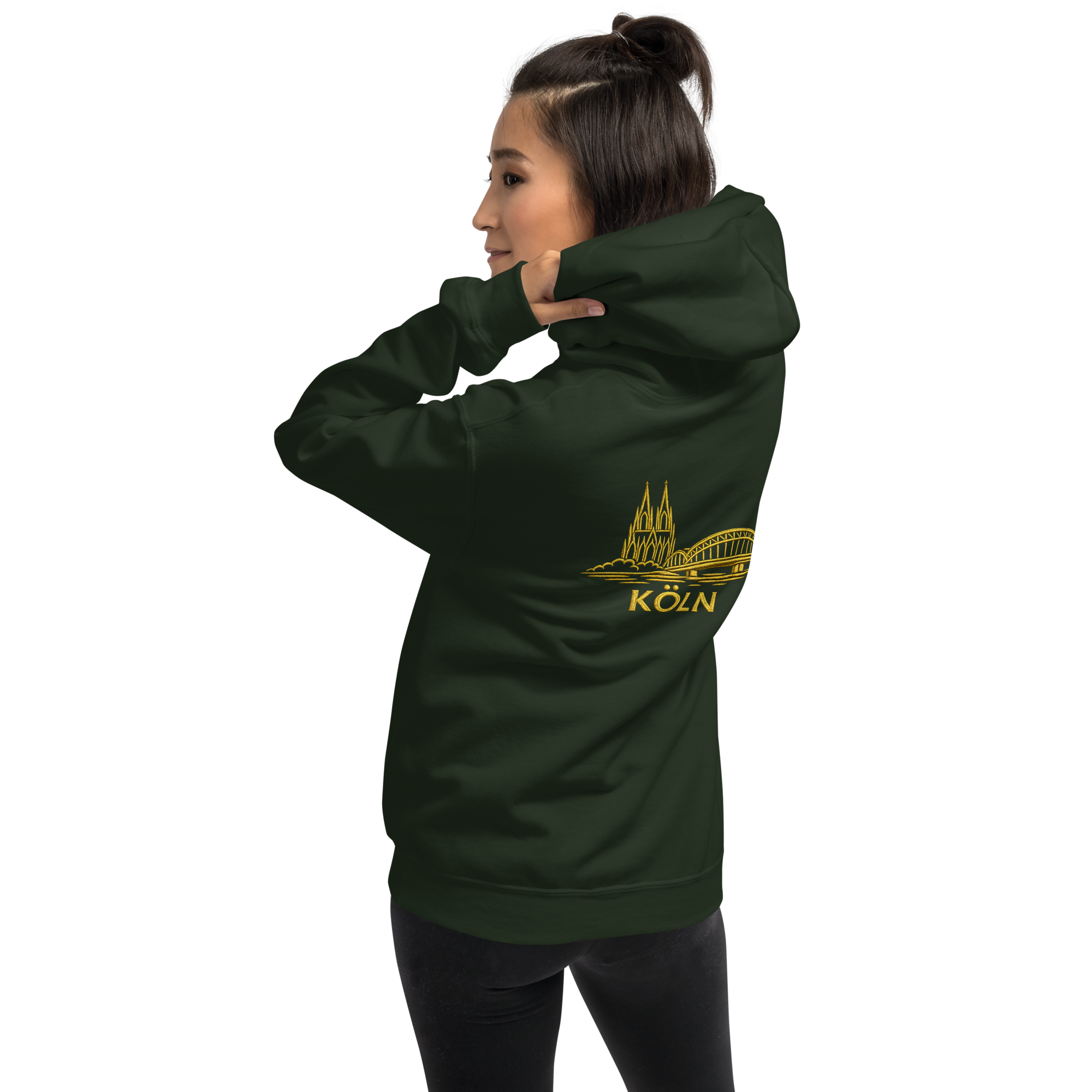 Person wearing a forest green Köln hoodie with a yellow logo and text on a white background
