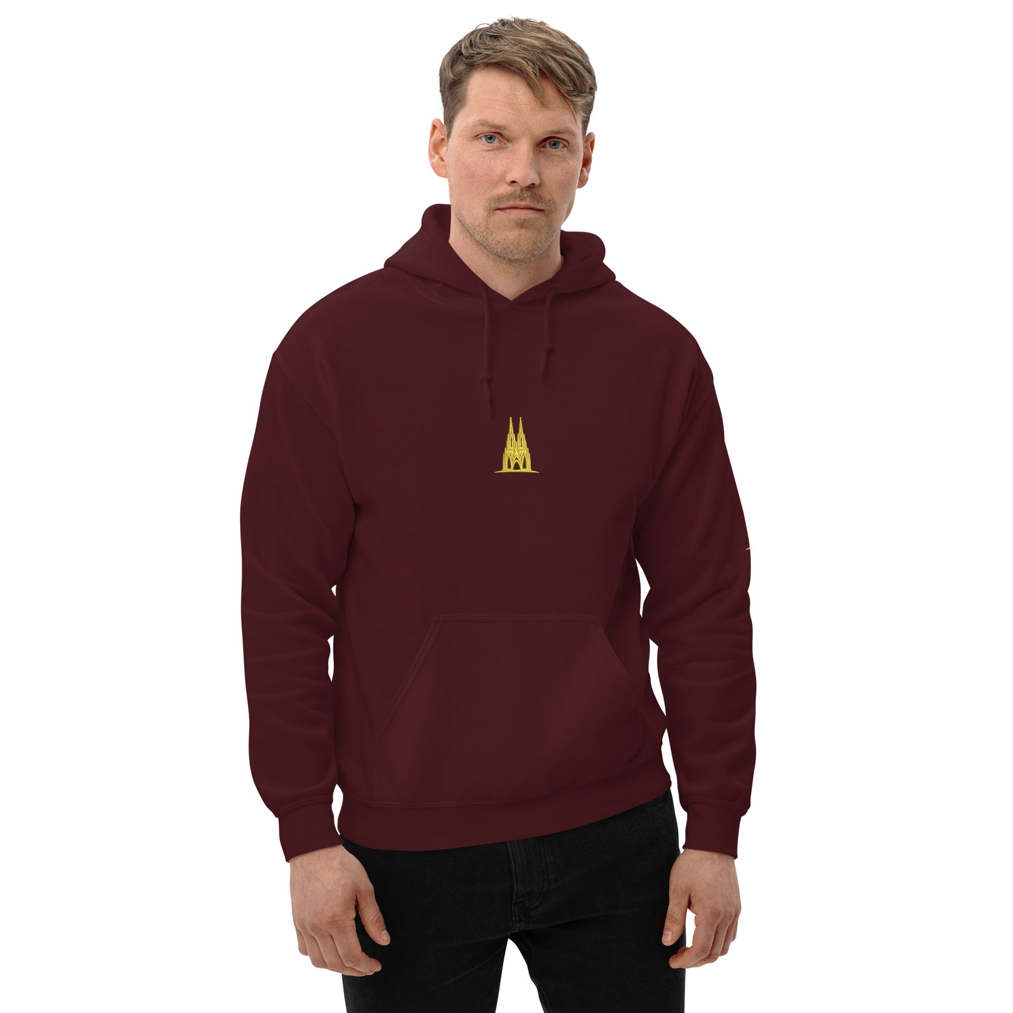Man wearing a maroon hoodie with a golden köln logo on a white background