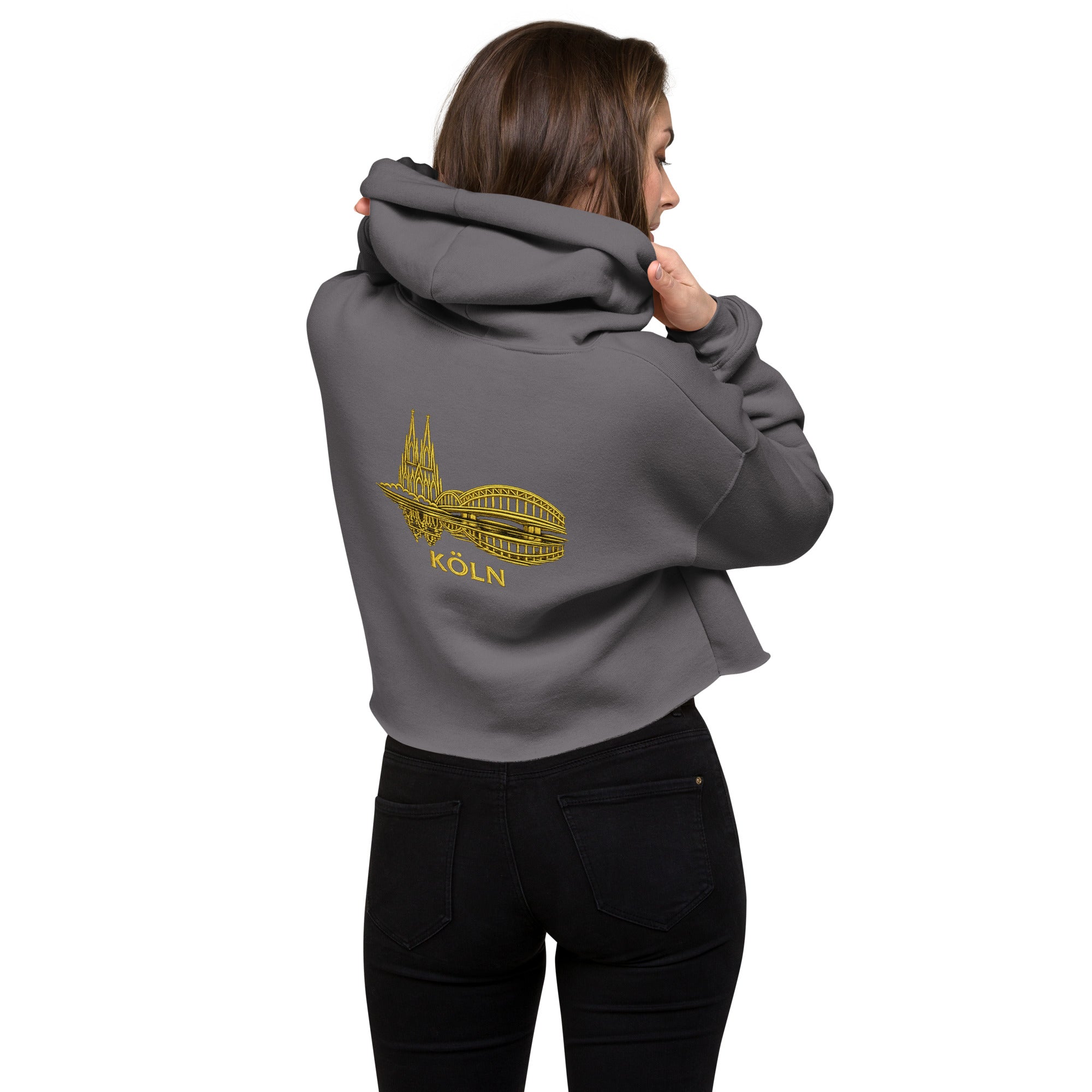 Person wearing a gray hoodie with a yellow 'Köln' design on the back, standing against a white background.